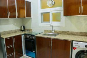 una piccola cucina con lavandino e lavastoviglie di ALmansor furnished apartment 3 a Salalah