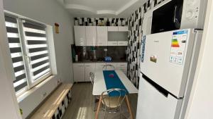 a small kitchen with a refrigerator and a table at Ca acasa Corbu 2 in Corbu