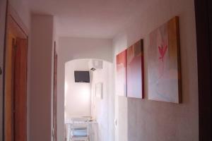 un corridoio con tre dipinti sul muro di Golfo di Marinella stupendo bilocale vista mare a Marinella