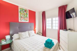 1 dormitorio con 1 cama con pared roja en Apartment in front of the Beach, en Pineda de Mar