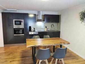 a kitchen with a wooden table and chairs at FeWo nähe Europapark in Hugsweier