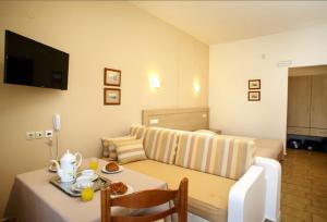 a hotel room with a bed and a table with a table sidx sidx at Lili Apartments,oasis 2,5 km from Hania center in Parigoría