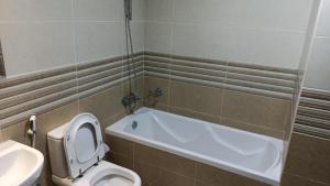 a bathroom with a tub and a toilet and a sink at Furnished Studio Apartments for rent in Dubai in Dubai