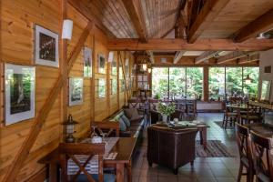 a living room with wooden walls and tables and chairs at Boutique Hotel Roja in Roja
