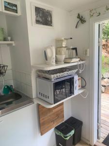 a kitchen with a microwave on a shelf at Lyckorna 62:1 in Ljungskile