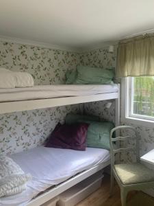 two bunk beds in a room with a chair at Lyckorna 62:1 in Ljungskile