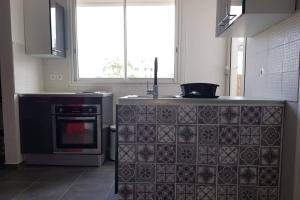uma cozinha com um fogão e um lavatório em Le Repère tropical à la Marina em Pointe-à-Pitre