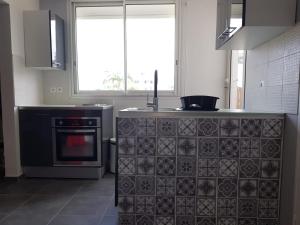 uma cozinha com um fogão preto e uma janela em Le Repère tropical à la Marina em Pointe-à-Pitre