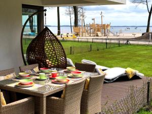 stół z kubkami i talerzami obok placu zabaw w obiekcie APARTAMENT ELEGANCE YELLOW w Nautica Resort w mieście Giżycko