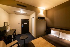 a hotel room with a bed and a desk and a table at Kyoto Central Inn in Kyoto