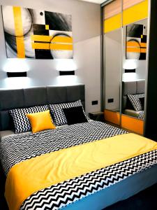 - une chambre avec un lit doté d'oreillers jaunes et noirs dans l'établissement APARTAMENT ELEGANCE YELLOW w Nautica Resort, à Giżycko