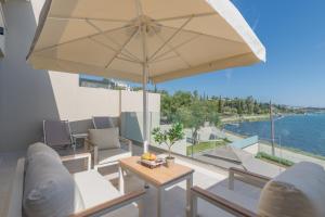 a patio with a table and a large umbrella at Swans Luxury Homes in Kommeno