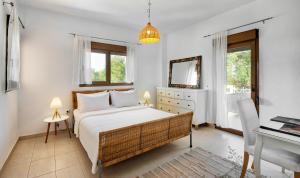 a bedroom with a bed and a desk and window at Sanidiamonds in Sani Beach