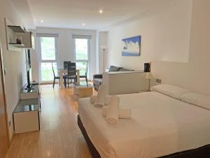 a white bedroom with a bed and a living room at Apartamentos Vallnord 3000 in Arinsal