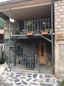 ein Gebäude mit einem Balkon mit Topfpflanzen darauf in der Unterkunft Guesthouse Venera in Mestia