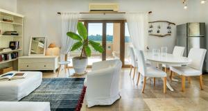 a living room with a table and white chairs at Sanidiamonds in Sani Beach