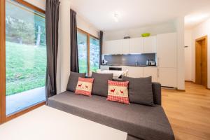 ein Wohnzimmer mit Couch und großem Fenster in der Unterkunft Residenz Cuolm Liung 52 in Laax