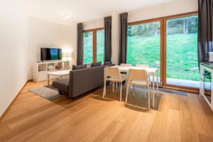 ein Wohnzimmer mit einer Couch und einem Tisch und Stühlen in der Unterkunft Residenz Cuolm Liung 52 in Laax + 2 Fotos