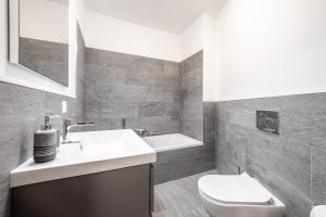 ein Badezimmer mit Waschbecken, Toilette und Badewanne in der Unterkunft Residenz Cuolm Liung 52 in Laax