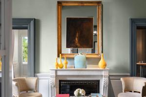 a living room with a fireplace and a mirror at The Place Firenze in Florence