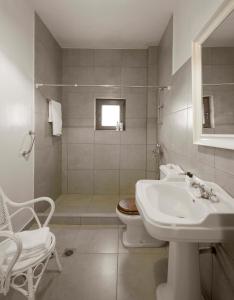 a white bathroom with a sink and a toilet at Sanidiamonds in Sani Beach