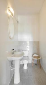a white bathroom with a sink and a toilet at Sanidiamonds in Sani Beach