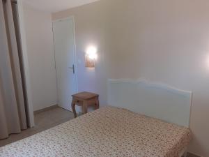 1 dormitorio con cama, mesa y luz en Gîte Gard 4-5 personnes Piscine et rivière, en Saint-Julien-de-Cassagnas