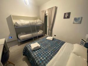 1 dormitorio con 1 cama con toallas plegables. en B&B Alto Salento - Pool and Sun, en Pulsano