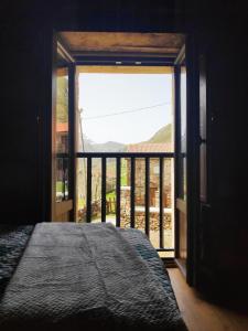 a bedroom with a bed and a large window at Apartamentos C'Ambrosio in La Peral +2 photos