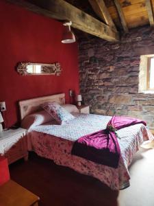 um quarto com uma cama e uma parede de pedra em Apartamentos C'Ambrosio em La Peral