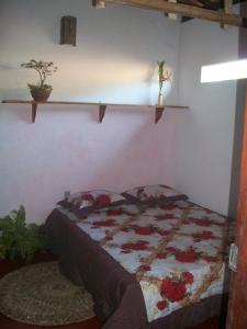 Un dormitorio con una cama con flores. en Casa da Jaca 1, en Itacaré