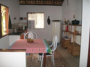 a kitchen with a table and chairs in a kitchen at Casa da Jaca 1 in Itacaré