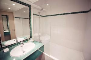 La salle de bains est pourvue d'un lavabo, de toilettes et d'un miroir. dans l'établissement Best Western Astoria, à Juan-les-Pins