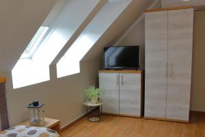 a room with a tv and a cabinet with a television at Hegylánc Fogadó in Sótony