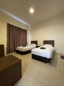 a hotel room with two beds and a window at Awin swiss garden residence in Kuantan