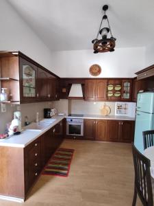 a large kitchen with wooden cabinets and a chandelier at Anemi in Kamilari