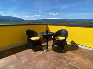 two chairs and a table on a balcony with a view at RINGRAST Boxenstopp mit HERZ in Spielberg