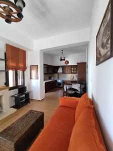 a living room with a couch and a kitchen at Anemi in Kamilari