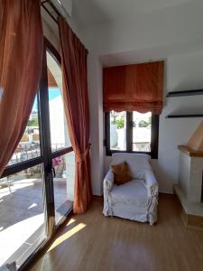 a living room with a couch and windows at Anemi in Kamilari