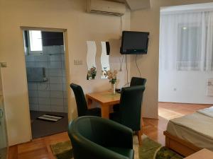 a small room with a table and chairs and a television at Apartman Zivanovic1 in Banja Koviljača