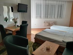 a small room with a bed and a table and chairs at Apartman Zivanovic1 in Banja Koviljača