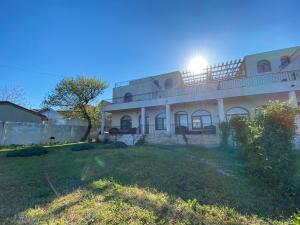 a large white house with the sun shining on it at Vila Seascape in 2 Mai
