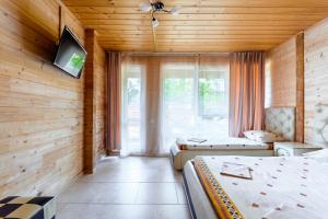 a room with two beds and a television in it at Отель из Бруса in Lermontovo