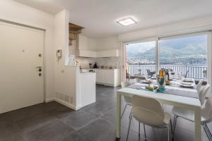 cocina y comedor con ventana grande en New Eleven Apartment on Como Lake, en Oliveto Lario