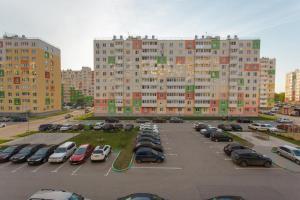 a parking lot with cars parked in front of tall buildings at СВЕЖО! Basic - Студия У Озера На Бурнаковской in Nizhny Novgorod