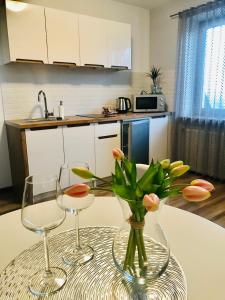 a table with two wine glasses and a vase with flowers at Bajkowa Panorama in Czerwienne