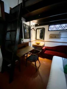 a room with a table and a couch and a bed at 103 - Bed and Brews in Bangkok