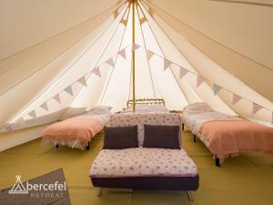a group of beds in a triangular tent at Abercefel Retreat in Llandysul