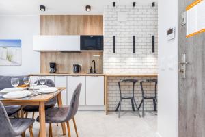 a kitchen and dining room with a table and chairs at Apartamenty Balticus by Renters in Międzyzdroje