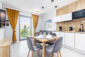 a kitchen and dining room with a table and chairs at Apartamenty Balticus by Renters in Międzyzdroje